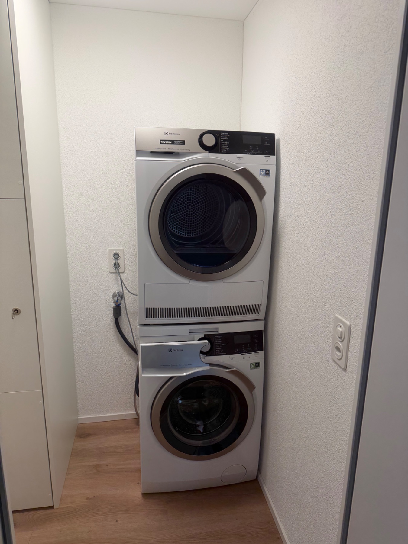 Waschturm/Waschmaschine und Wäschetrockner nebeneinander. Geräte stehen frei im Schranknischenbereich.